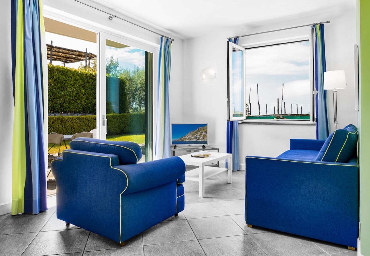 living room with garden access, tv and sofas, holiday apartment tosca, sant’agata sui due golfi, italy
