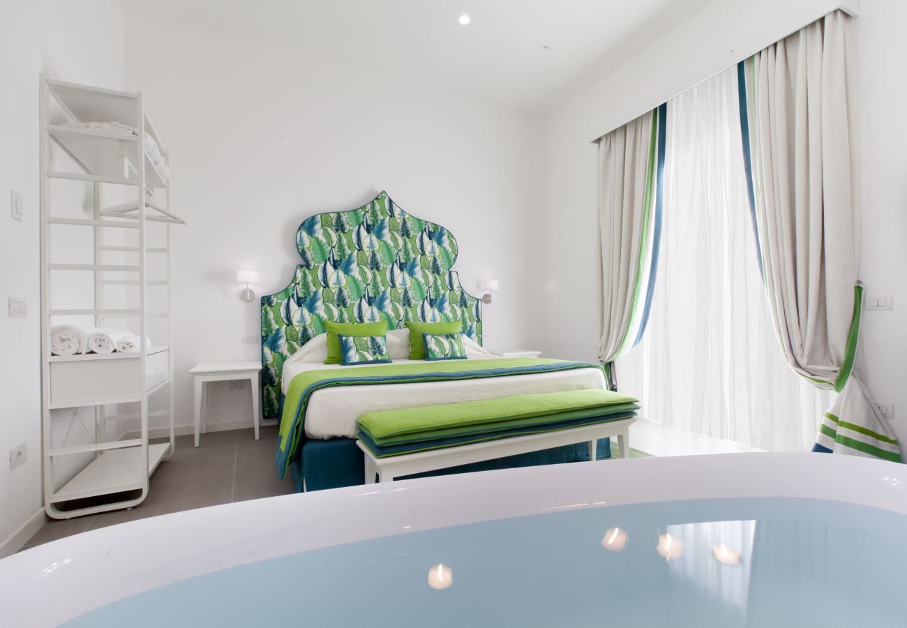 bright modern double bedroom with tub and balcony, holiday apartment green suite, sorrento, italy