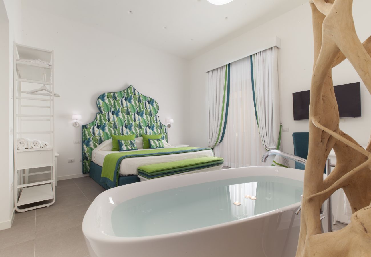 modern double bedroom in green, with tv and bath, holiday apartment green suite, sorrento, italy